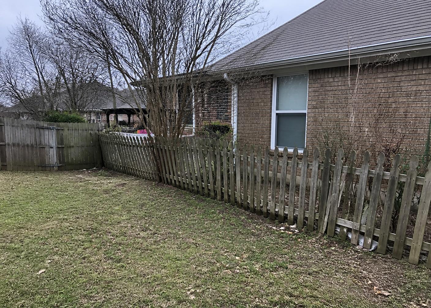 Old leaning fence leaving a backyard exposed